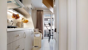 A narrow hallway with a kitchenette on one side, a child's bed in the center, and a dining area with chairs and a table at the end. - Holiday Apartment "Casa Doppia 2" with Sea View, Balcony & Wi-Fi (Zakynthos)
