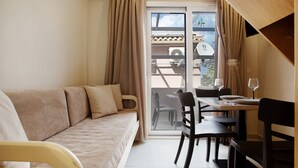 A room with a sofa, dining table, chairs, and a sliding glass door leading to an outdoor area. - Holiday Apartment "Casa Doppia 2" with Sea View, Balcony & Wi-Fi (Zakynthos)