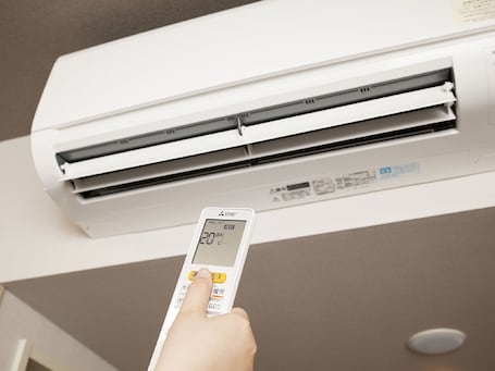 A hand pressing a button on a thermostat.. HOTEL ROUTE INN Grand NAKANO OBUSE - Shinshu-Nakanoekimae -