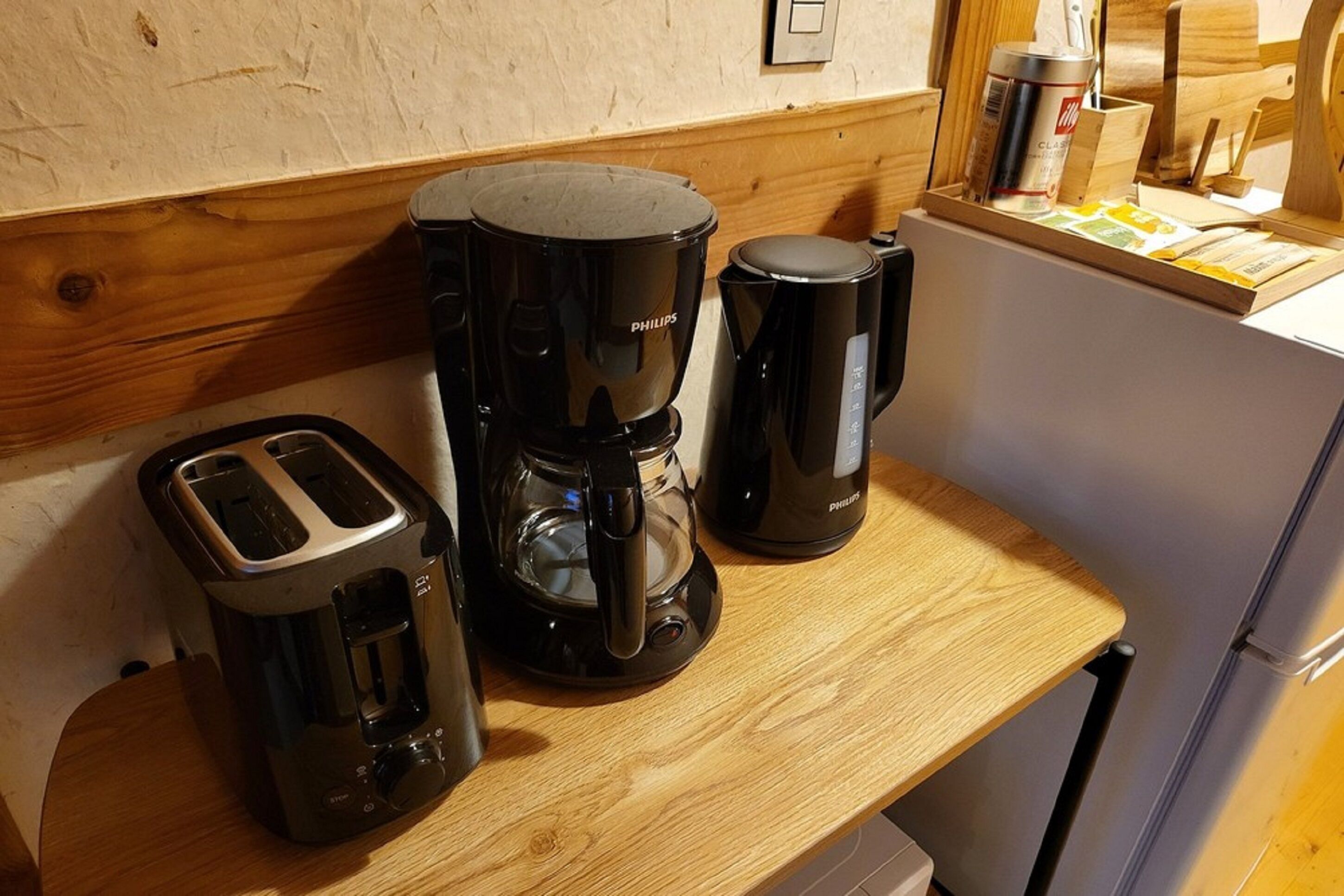 A kitchen counter with a toaster, a coffee maker, and a kettle.