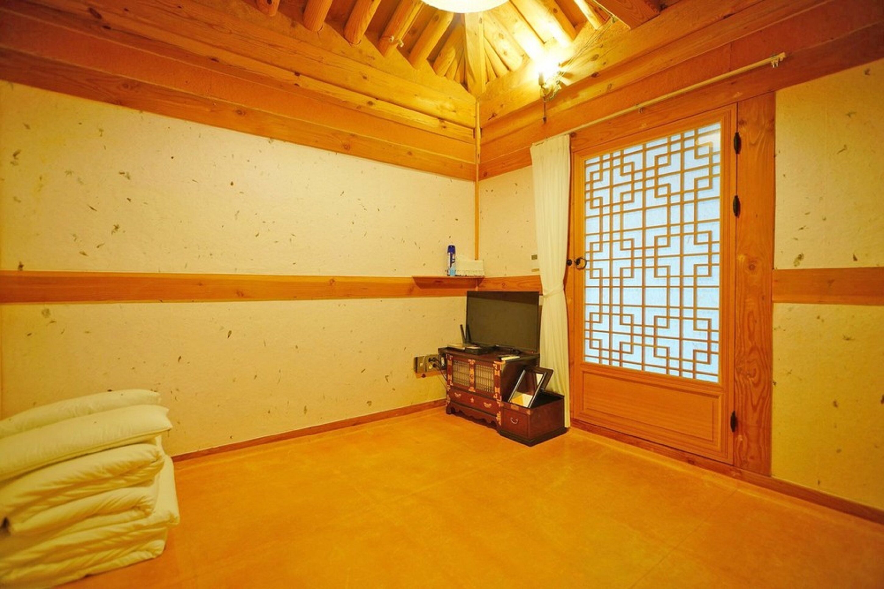 A traditional Japanese room with tatami flooring, a sliding door with a geometric pattern, and a small wooden cabinet.
