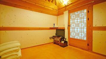 A traditional Japanese room with tatami flooring, a sliding door with a geometric pattern, and a small wooden cabinet.