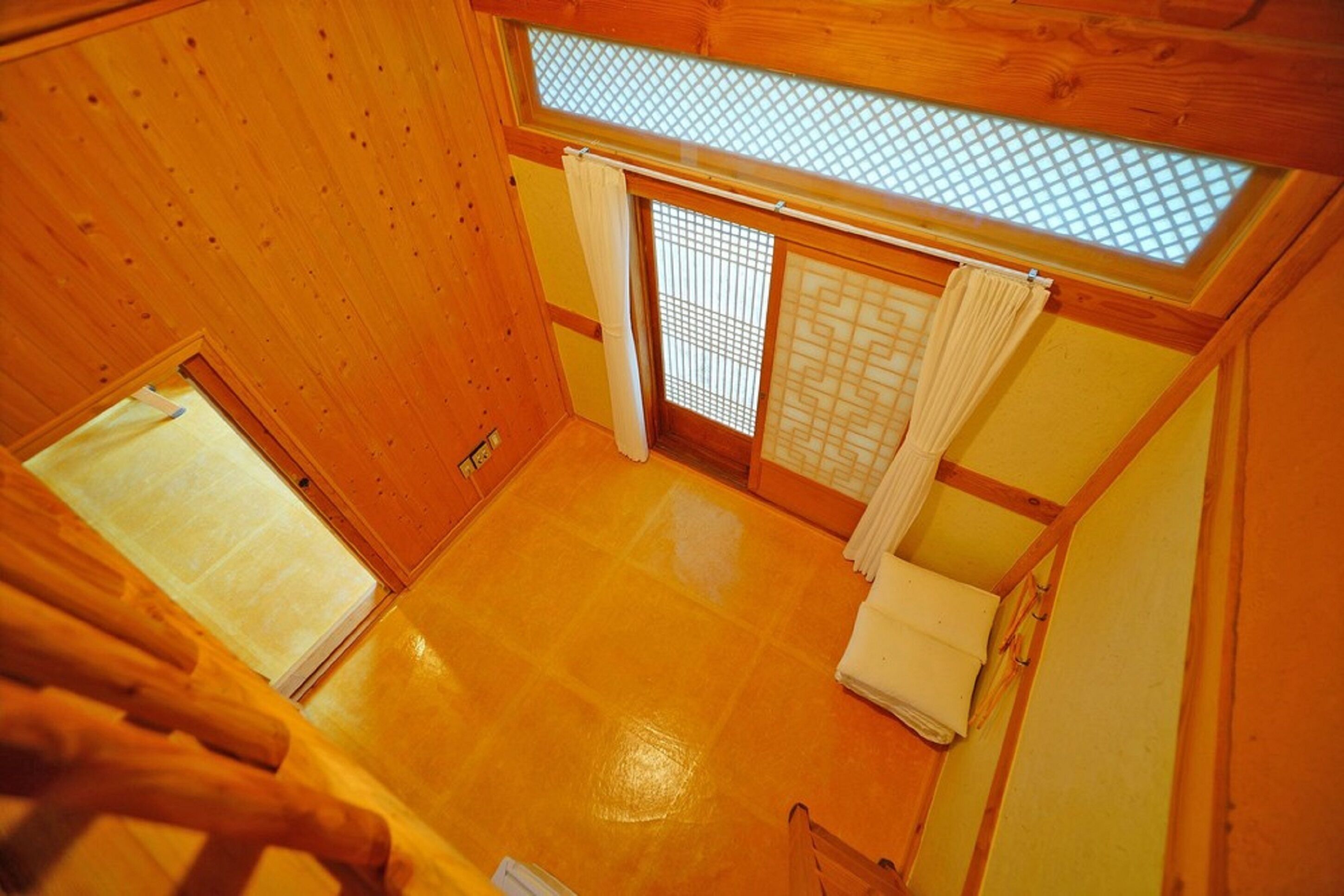 A traditional Japanese room with tatami flooring, sliding doors, and a skylight.