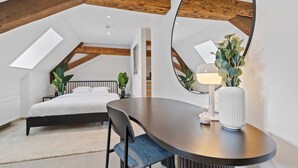 Ein modernes Schlafzimmer mit einem Bett, einem Schreibtisch und einem großen Spiegel.