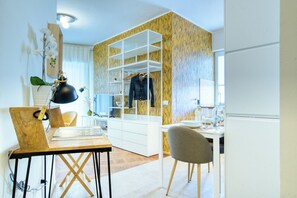 Habitación moderna con escritorio, silla, armario y una planta.