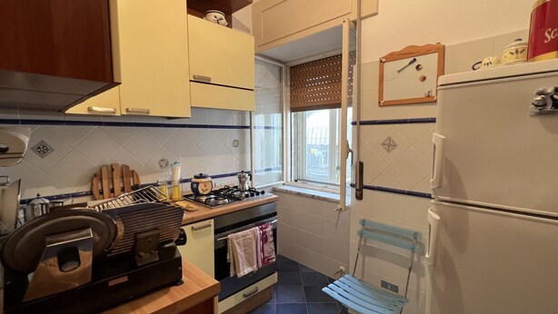 A compact kitchen with a stove, oven, and a small window. - All' Arco - Elegant apartment in the historic center of Fuscaldo (Fuscaldo)