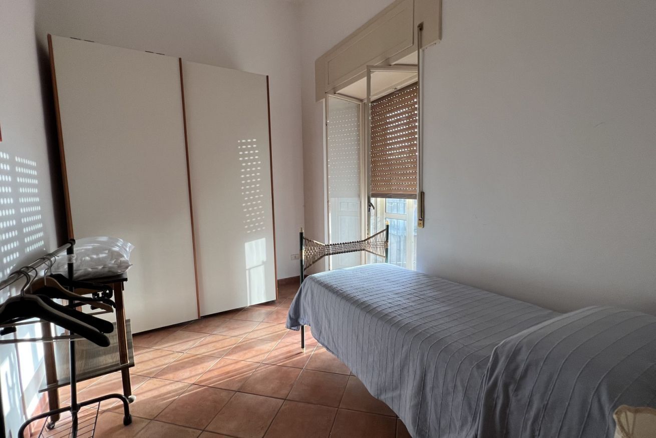 Una camera da letto con un letto, un armadio e un appendiabiti.