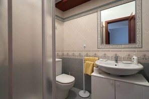 A bathroom with a toilet, sink, and mirror. - All' Arco - Elegant apartment in the historic center of Fuscaldo (Fuscaldo)