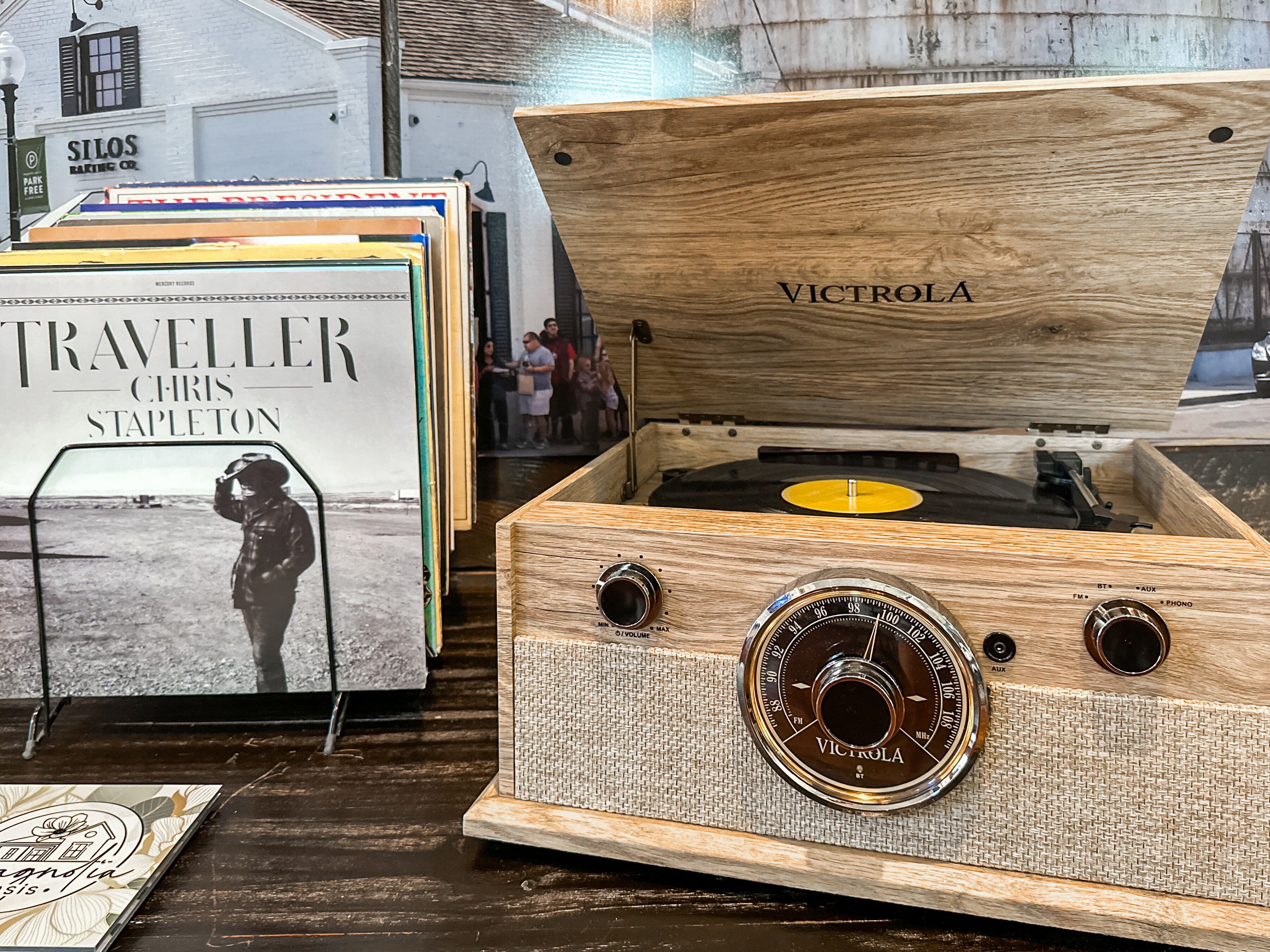 A vintage Victrola radio in a wooden box with a vinyl record inside.