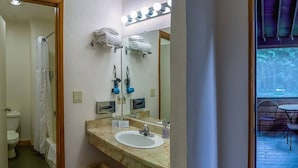 Une salle de bain équipée d’un lavabo, d’un miroir, d’un porte-serviettes et d’un rideau de douche.