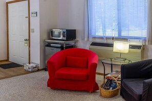Relax in this cozy living space with a comfortable armchair, reading nook, and entertainment options.