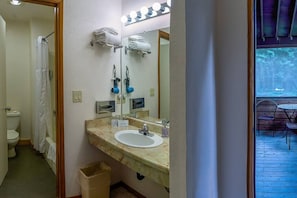 Bathroom features a sink, mirror, toilet, shower, and towel racks.
