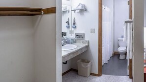 A bathroom with a marble sink, a toilet, and a shower curtain. - Lodge Room 6 at Green Springs Inn (Ashland)