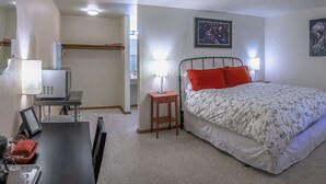 A bedroom with a bed, bedside table, lamp, and a desk with a chair. - Lodge Room 6 at Green Springs Inn (Ashland)