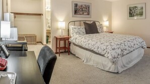 A bedroom with a bed, bedside tables, a desk, and a chair. - Lodge Room 4 with Jacuzzi Tub at Green Springs Inn (Ashland)