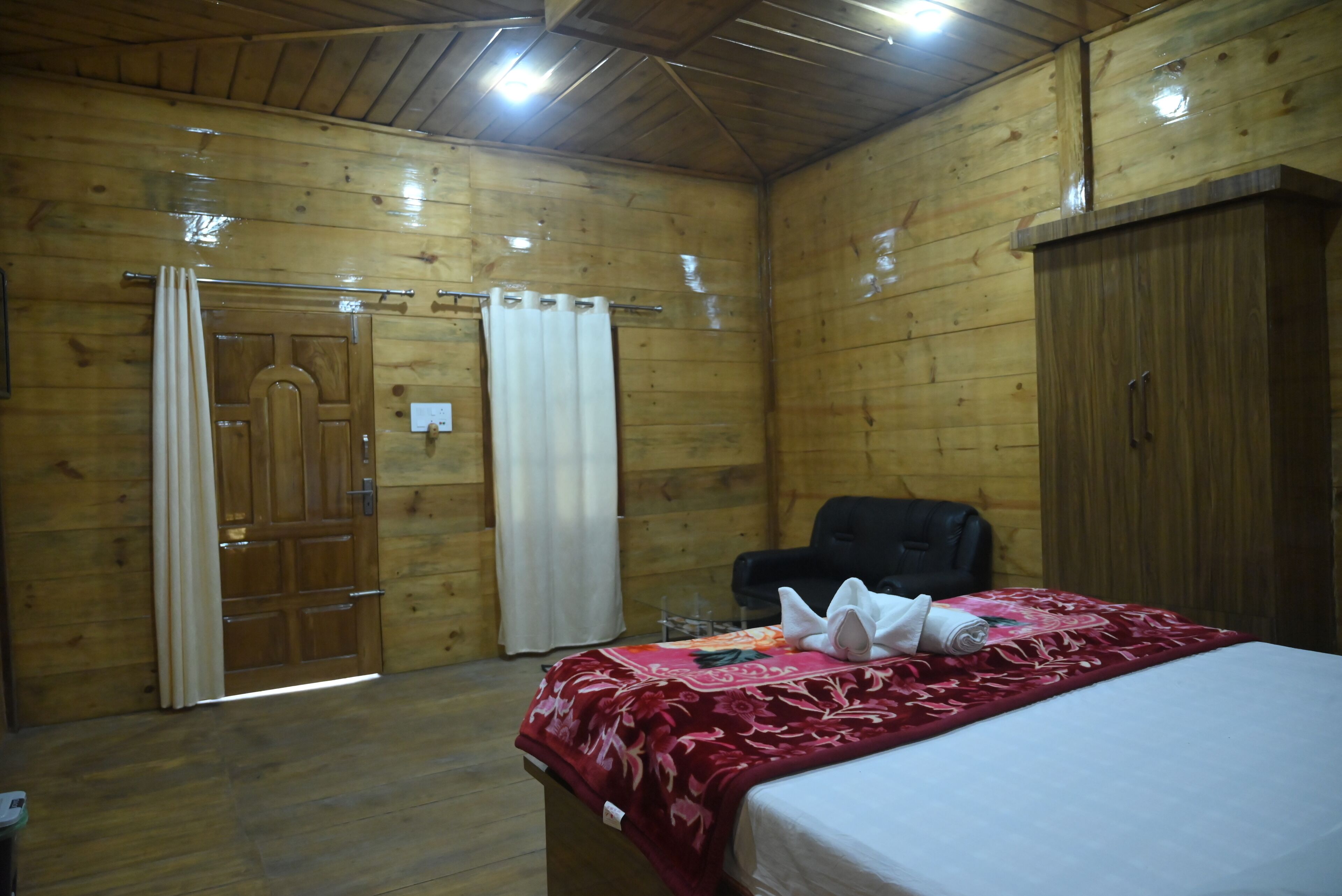 Una habitación de madera con una cama, una silla y un armario.