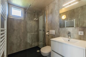 A modern bathroom with a shower, toilet, and sink. - EuroParcs Cadzand (Cadzand-Bad)