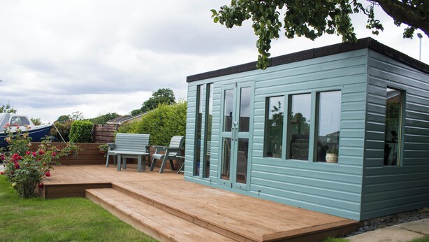 A small, light blue wooden building with a deck, a bench, and a table. - Spacious family cottage close to the beach and just a short drive from Edinburgh (Limekilns)
