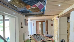A room with a foosball table, a hanging chair, and a door marked with the number 66. - Old house - 8 guests (Réveillon)