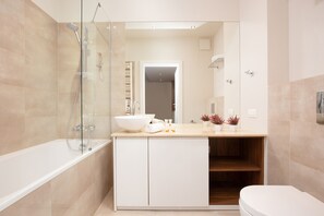 Bathtub, hair dryer, towels, shampoo