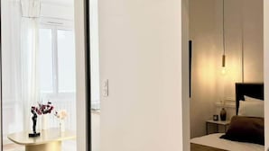 Een moderne slaapkamer met een bed, nachtkastje en een hanglamp.