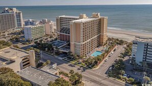A hotel with multiple floors, a swimming pool, and a view of the beach. - Direct Oceanfront Views,Pools Caravelle,HIGH Floor (Myrtle Beach)