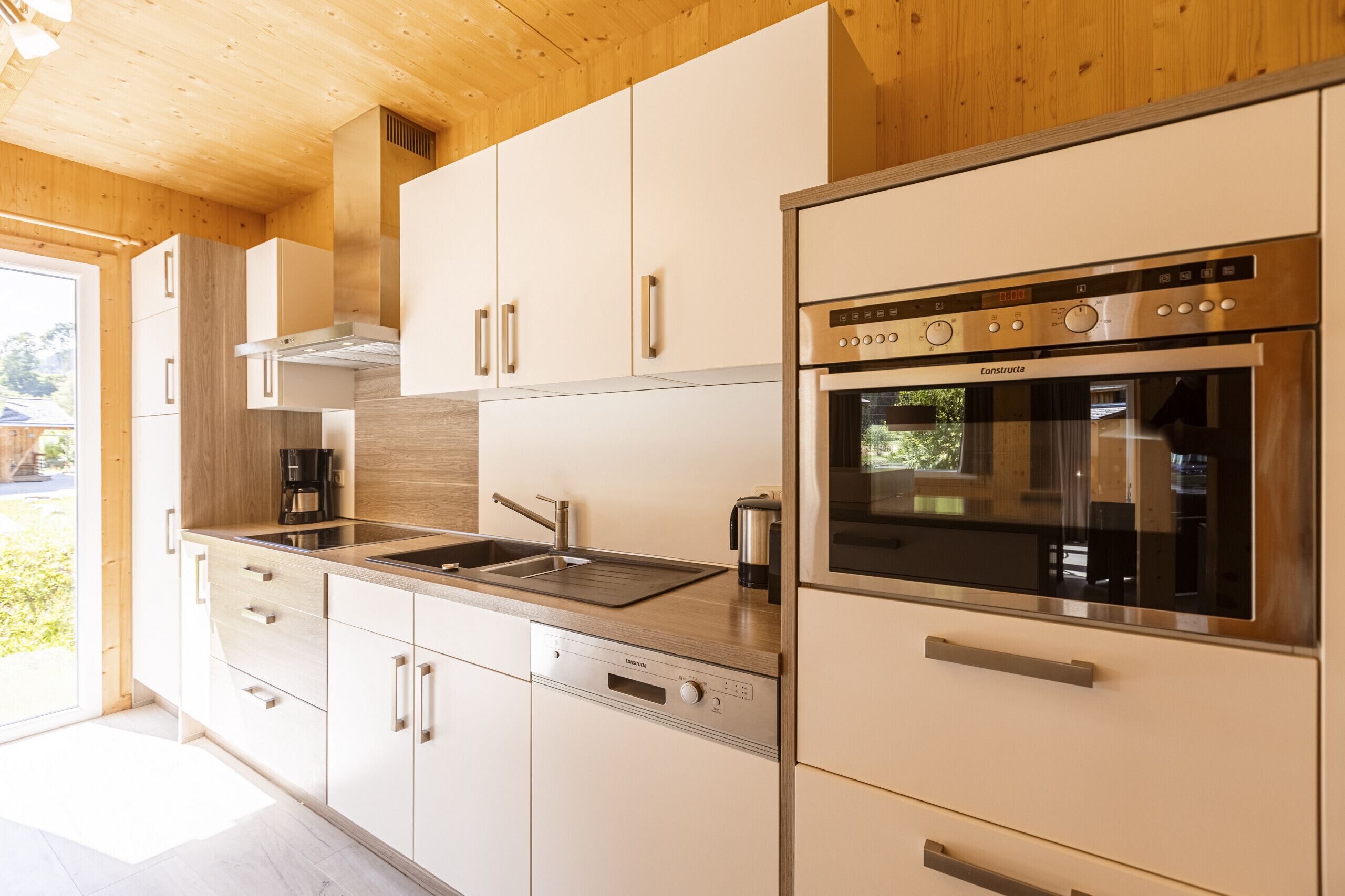 A modern kitchen with stainless steel appliances, wooden cabinets, and a dishwasher.