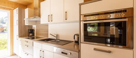 A modern kitchen with stainless steel appliances, wooden cabinets, and a dishwasher.
