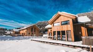 Wooden cabins with large windows, a covered outdoor area, and a snowy landscape. - Premium Chalet # 10 with IR-sauna & whirpool (Murau)