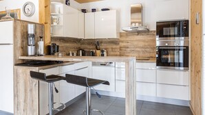 Een moderne keuken met witte kastjes, een houten aanrechtblad en roestvrijstalen apparatuur.