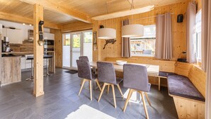Een modern houten interieur met een eethoek, keuken en bar.