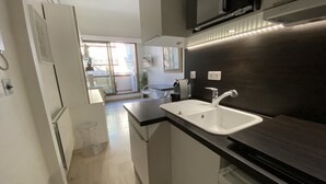 Uma cozinha moderna com pia, bancada e micro-ondas acima.