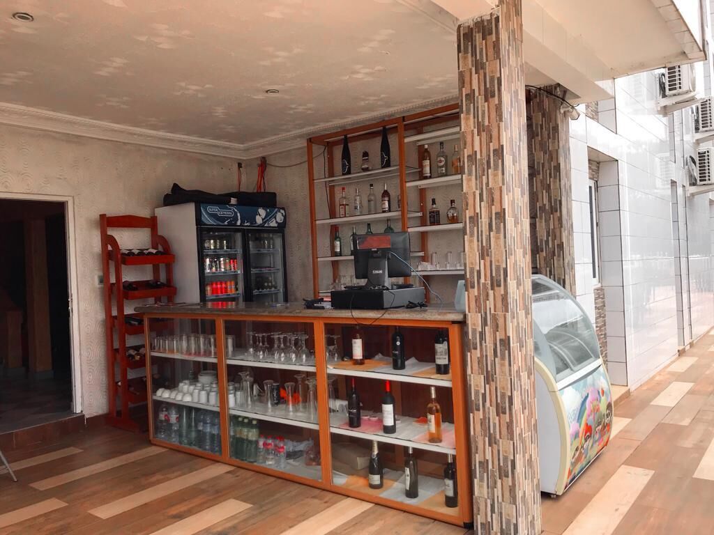 Une pièce dotée d’un plancher en bois, d’une vitrine en verre contenant des bouteilles de vin, d’un réfrigérateur et d’un distributeur automatique.