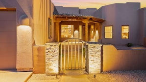 A building with a stone entrance gate, a number '29707' above the door, and a covered area with windows. - Desert Oasis | TROON NORTH | Golf | Heated Pool (Scottsdale)
