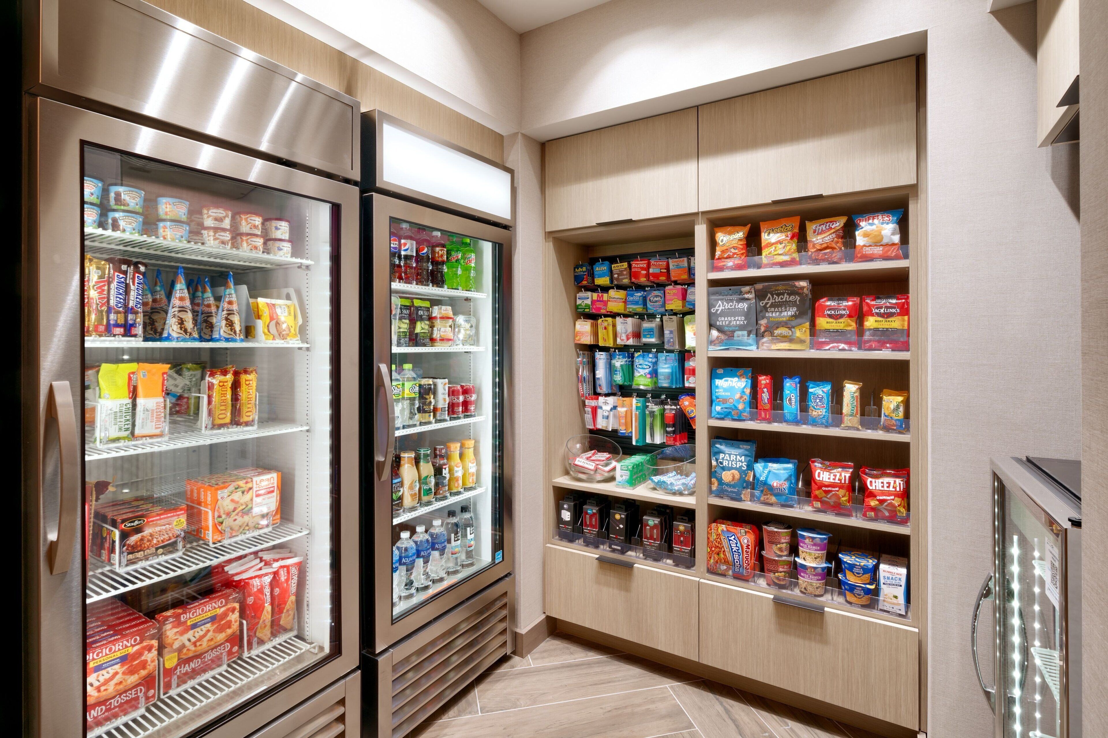 Ein Bereich für Selbstbedienung mit Snacks und Getränken, inklusive Kühlregalen und Regalen, die mit Snacks, Getränken und Soßen gefüllt sind.