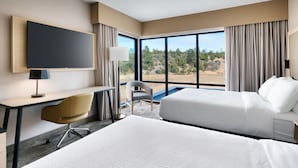 A hotel room with two beds, a desk, a chair, a TV, and a large window offering a view of the outdoors. - Fairfield Inn & Suites by Marriott Show Low (Show Low)