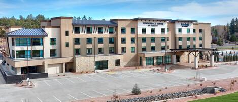 A modern hotel with a parking lot and a covered walkway.