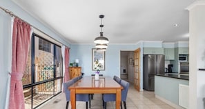 Enjoy meals in the kitchen and dining area, featuring a refrigerator, microwave, and wooden table with four chairs.