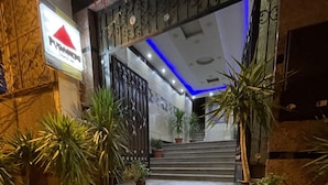 A staircase leading to a hotel entrance with potted plants on either side. - pyramids tower view inn (Giza)