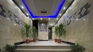 A set of marble stairs leading to a door with a geometric patterned wall on either side. - pyramids tower view inn (Giza)