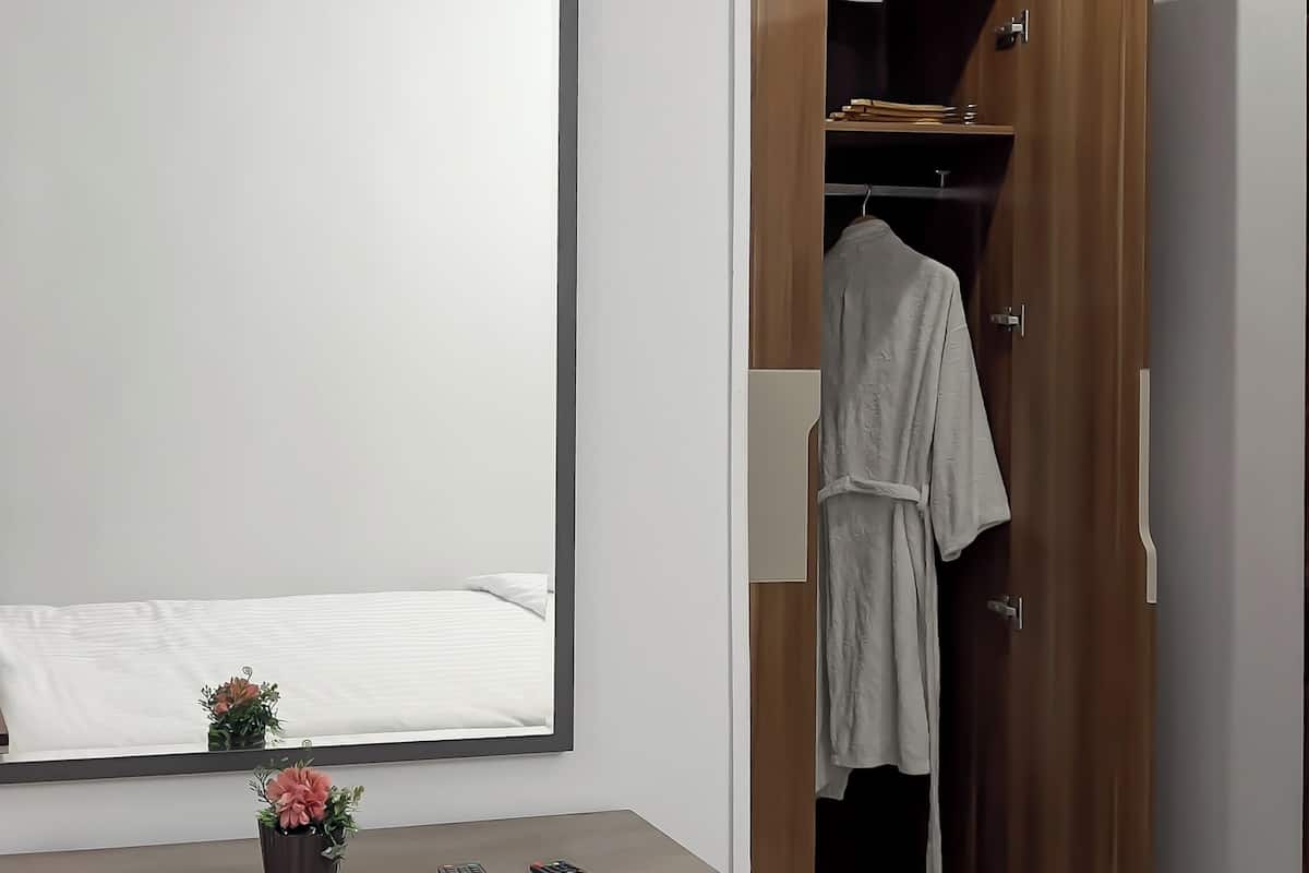A modern bathroom with a mirror, a sink, a toilet, and a shower area.