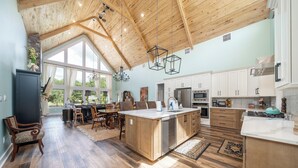 Una cocina amplia con armarios de madera, una isla grande y un comedor con sillas y una mesa.