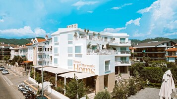 Ένα πολυώροφο ξενοδοχείο με μπαλκόνια, έναν σκεπαστό εξωτερικό χώρο με καθίσματα και θέα στην γύρω περιοχή.