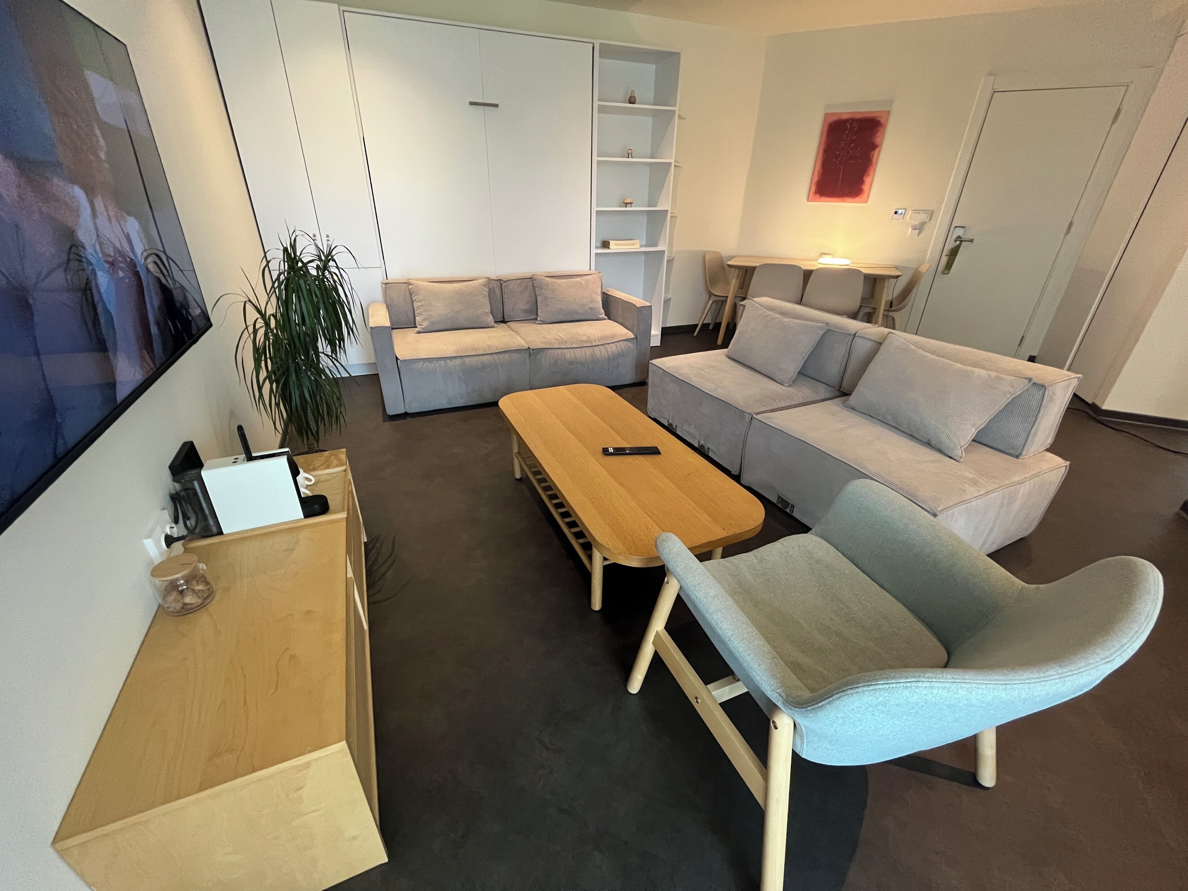 A modern living room with a sofa, a coffee table, and a TV.