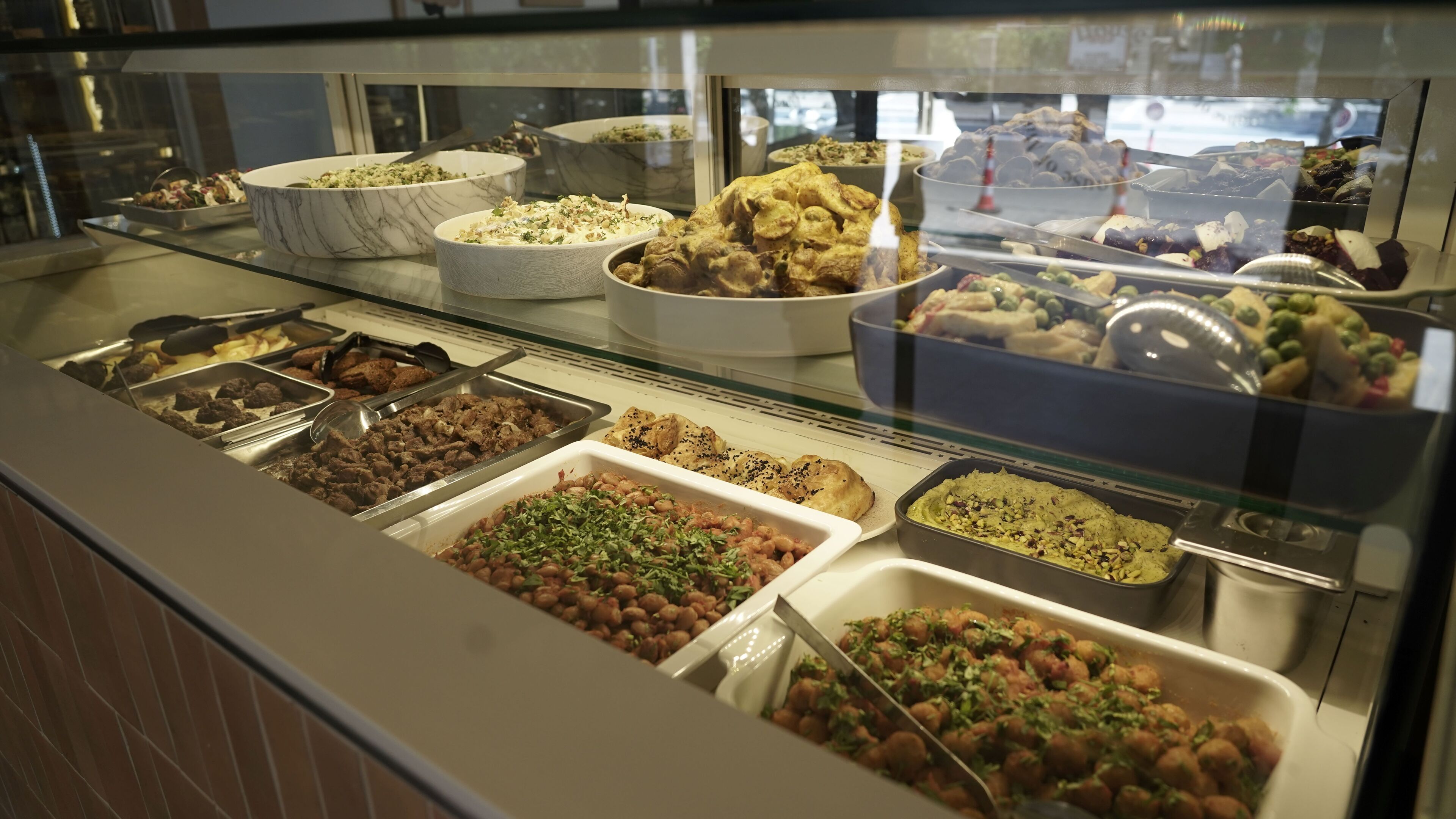 En buffet med et udvalg af retter, herunder salater, kød og desserter.