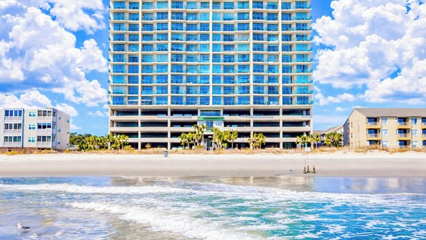 A modern hotel with multiple floors, a flat roof, and a beach view. - North Shore Villas 806! 3BR/3BA Luxury Condo with Stunning Views! (North Myrtle Beach)