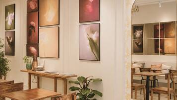 A dining area with wooden furniture, a potted plant, and artwork on the walls.
