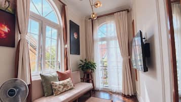 Una habitación acogedora con sofá, ventilador y televisión.