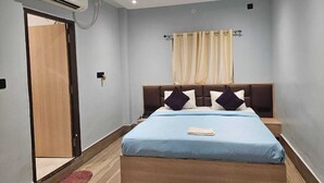 Ein Schlafzimmer mit Bett, Nachttischen, Klimaanlage, Deckenventilator und einer Tür.