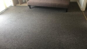 A grey carpeted room with a brown sofa and two red pillows with "KEEP CALM & CARRY ON" text. - A wonderful house share: can accommodate up to 15 friends and family.  (Nottingham)